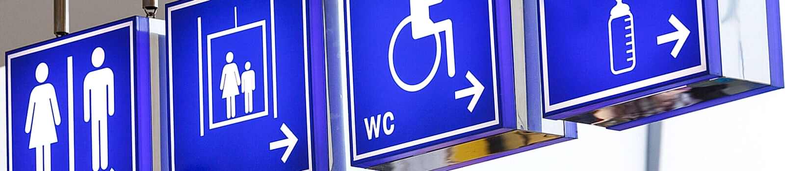 Mehrere blaue Wegweiser mit Pfeilen, die in unterschiedliche Richtungen weisen.